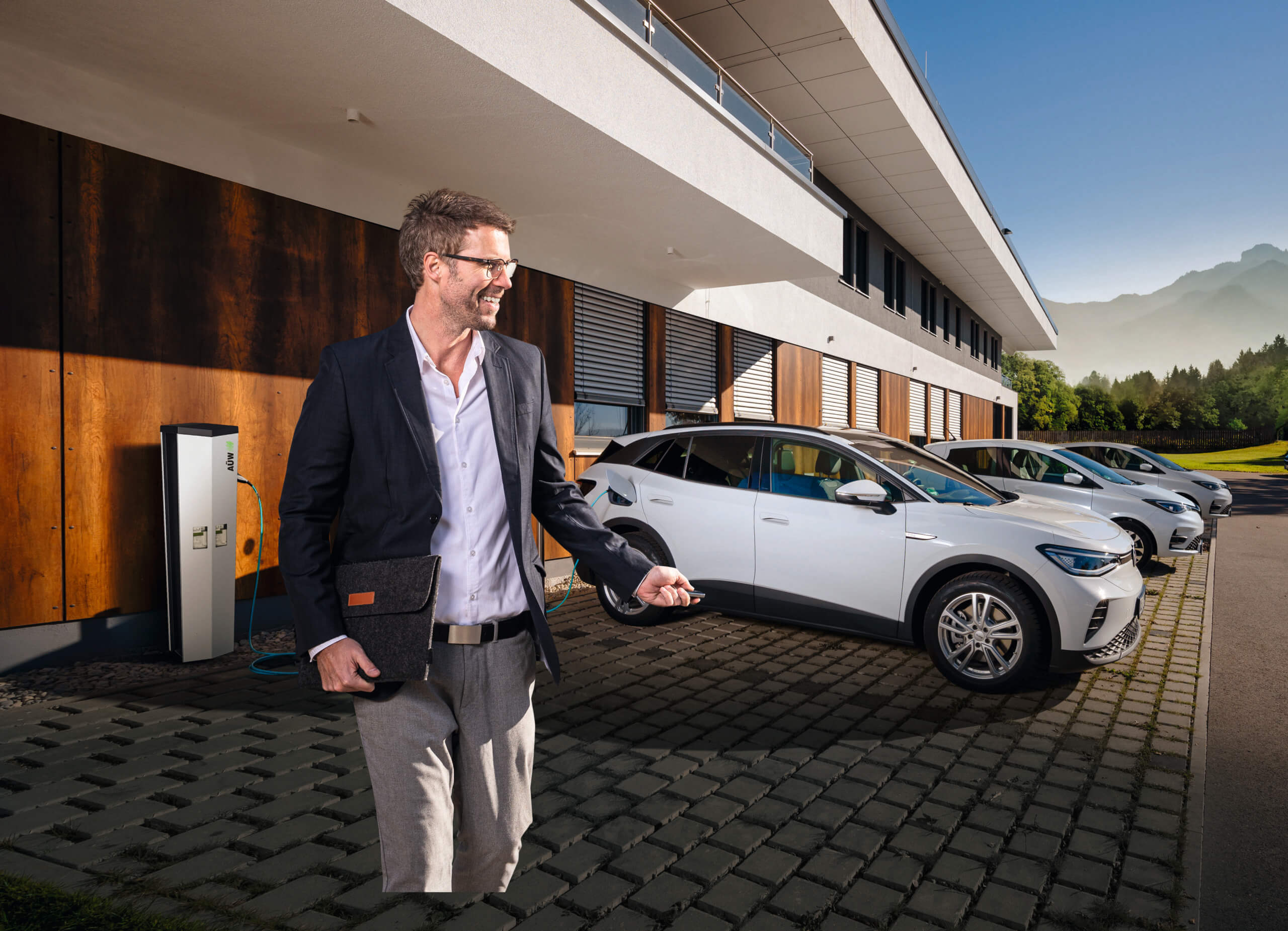 Geschäftsmann lädt E-Auto an Ladesäule