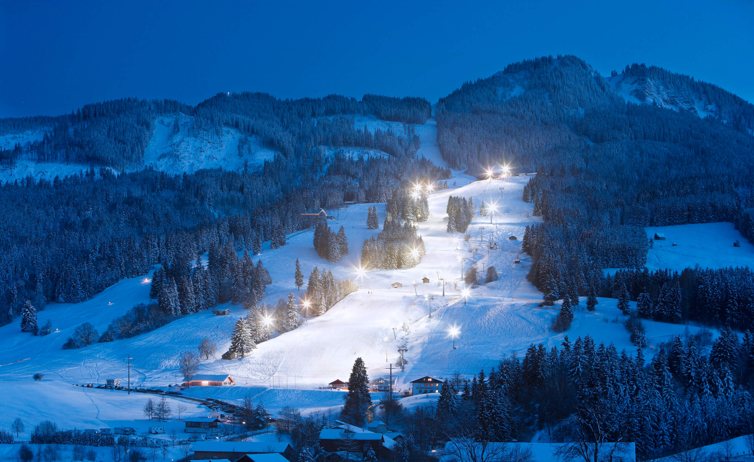 Beleuchtete Skipiste bei Nacht